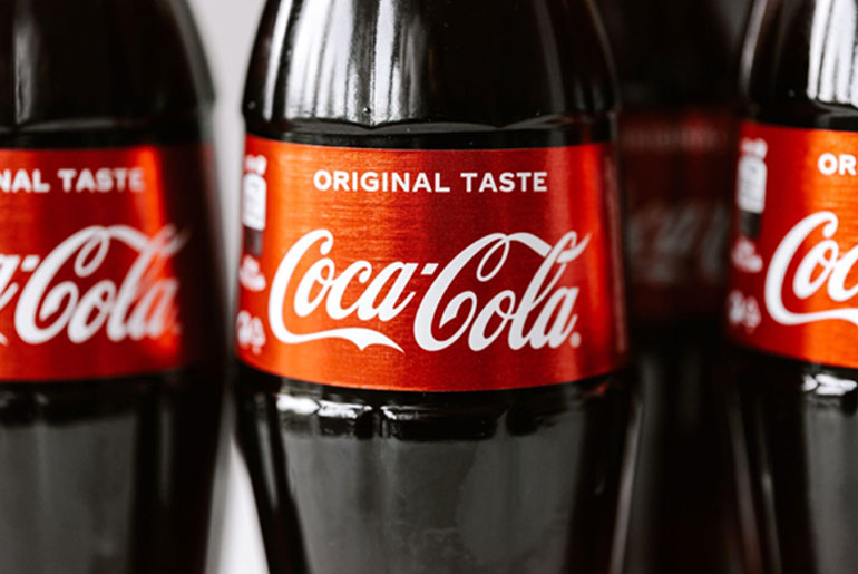 Close-up shot of the labels on three Coca-Cola bottles, original flavor